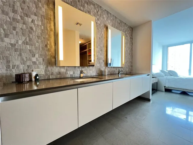 a bathroom with a double vanity sink and a large mirror