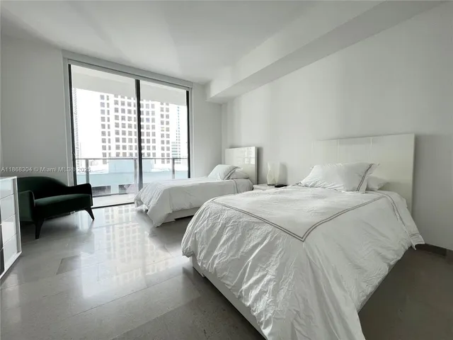 a bedroom with a bed a couch and a large window