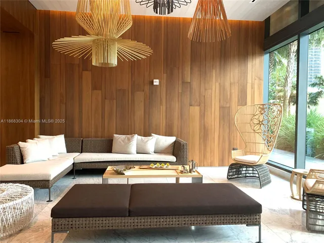 a living room with furniture a rug and a floor to ceiling window