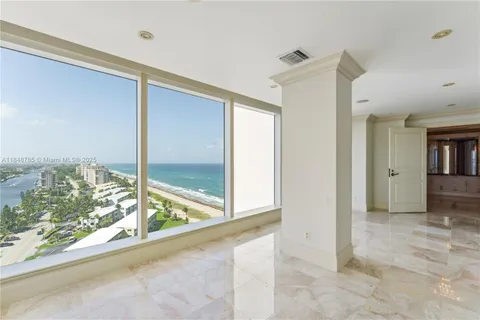 a view of a room with a large window and wooden floor