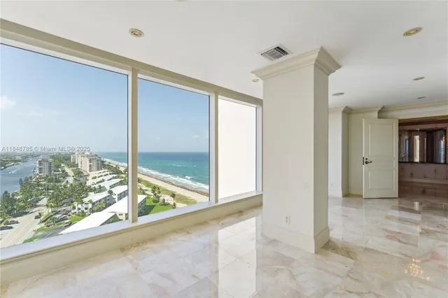 a view of a room with a large window and wooden floor