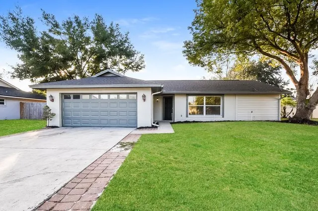 a front view of a house with a garden and trees