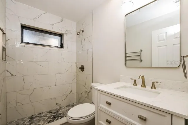 a bathroom with a sink a toilet and shower