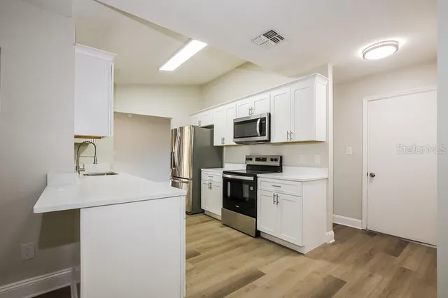 a kitchen with a sink appliances and cabinets