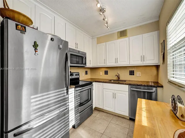 a kitchen with stainless steel appliances a stove a sink and a refrigerator