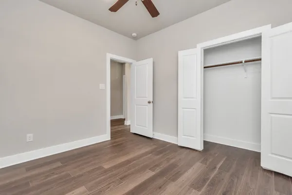an empty room with wooden floor and closet