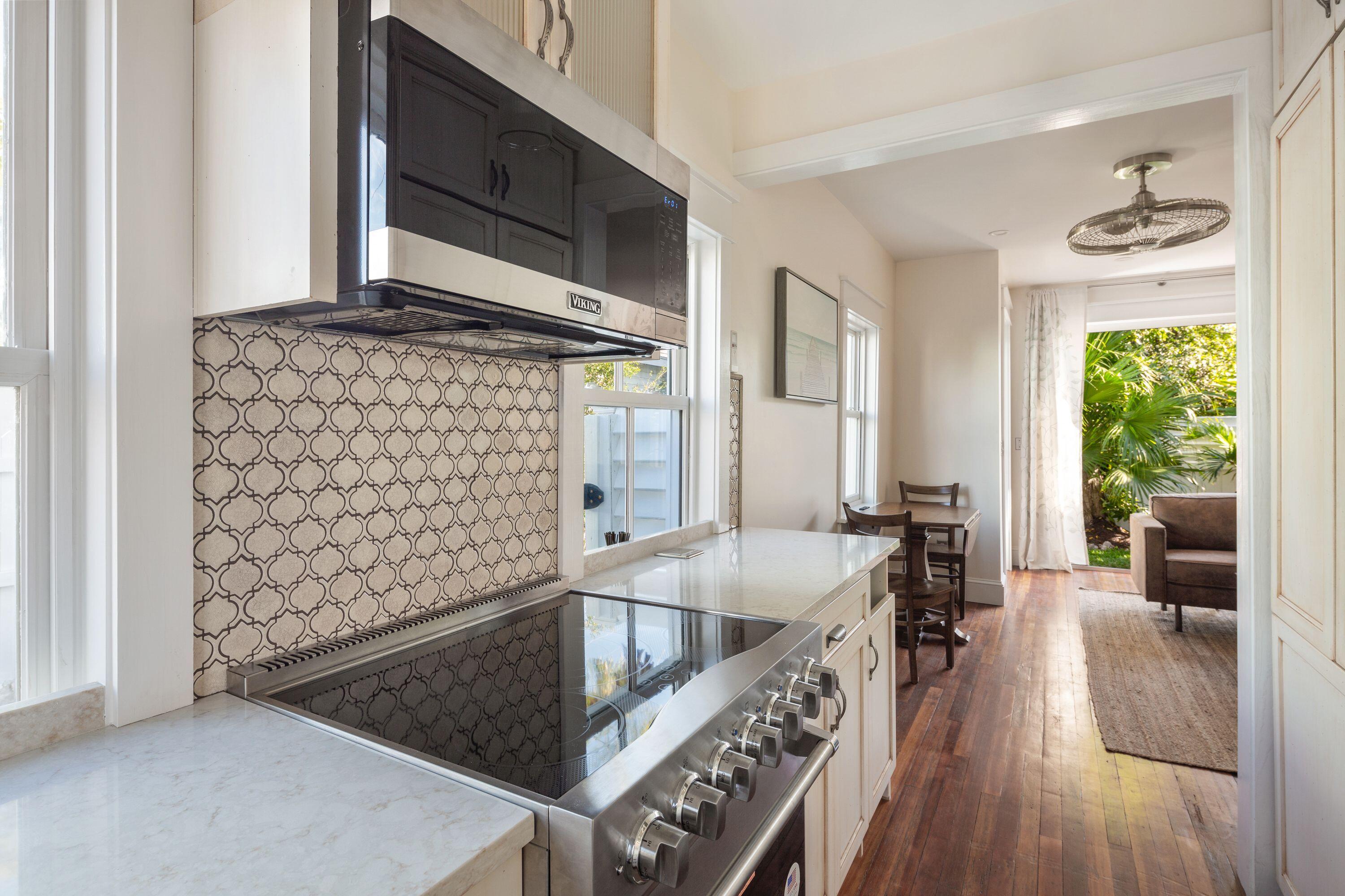 1007 Thomas Street Key West, FL 33040 - Photo 20 of 31 a kitchen with granite countertop a stove and a microwave