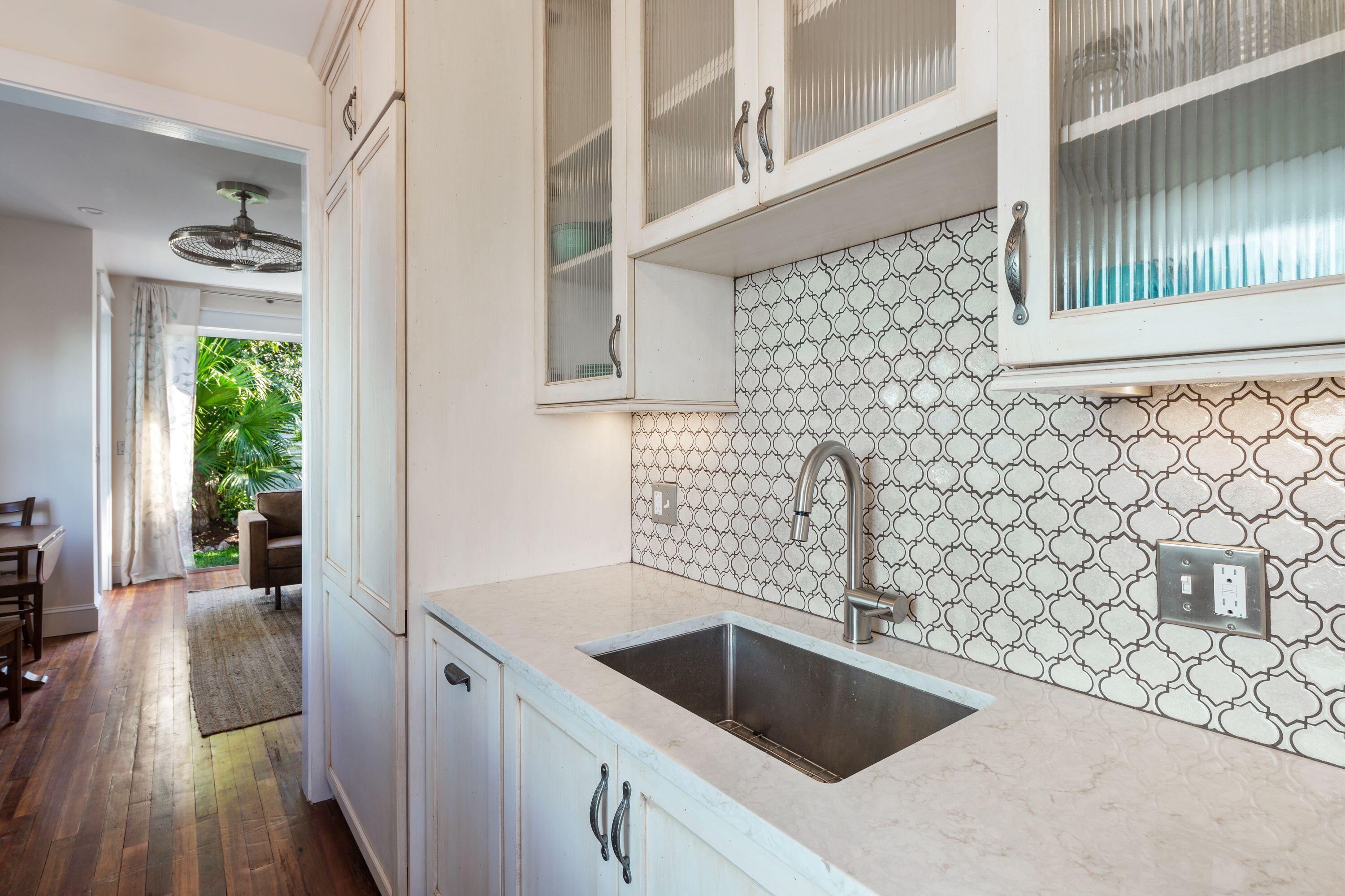 1007 Thomas Street Key West, FL 33040 - Photo 21 of 31 a kitchen with a sink and wooden cabinets