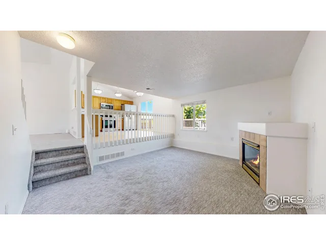 a living room with a window and a fireplace
