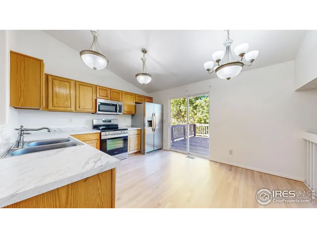 a kitchen with stainless steel appliances granite countertop a sink dishwasher and a stove with wooden floor