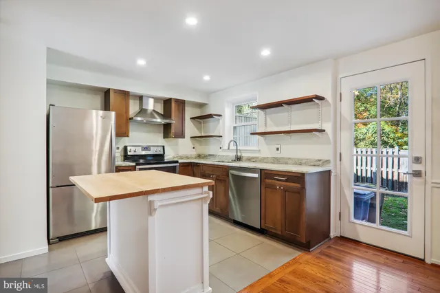 a kitchen with stainless steel appliances granite countertop a refrigerator sink and stove