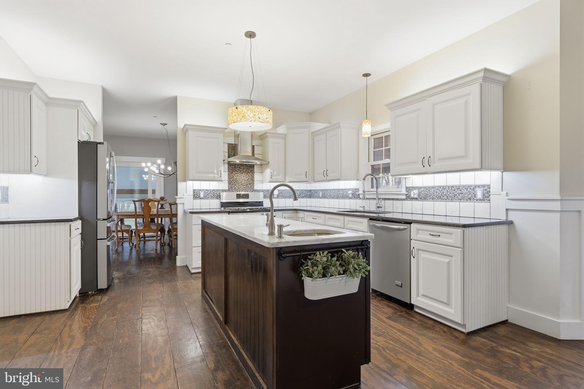 3852 Dark Hollow Road Furlong, PA 18925 - Photo 14 of 52 a kitchen with kitchen island granite countertop a sink appliances cabinets and wooden floor