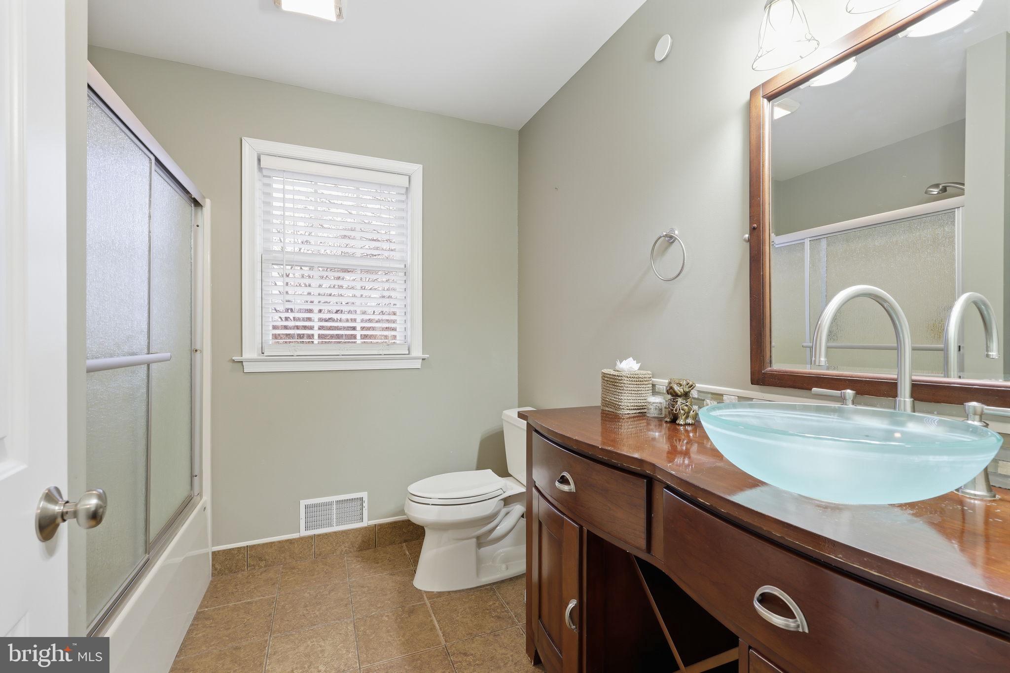 3852 Dark Hollow Road Furlong, PA 18925 - Photo 35 of 52 a bathroom with a granite countertop sink a toilet and a mirror