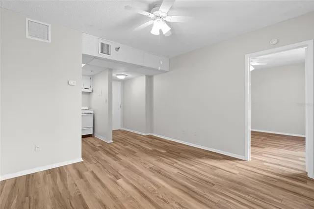 a view of empty room with wooden floor