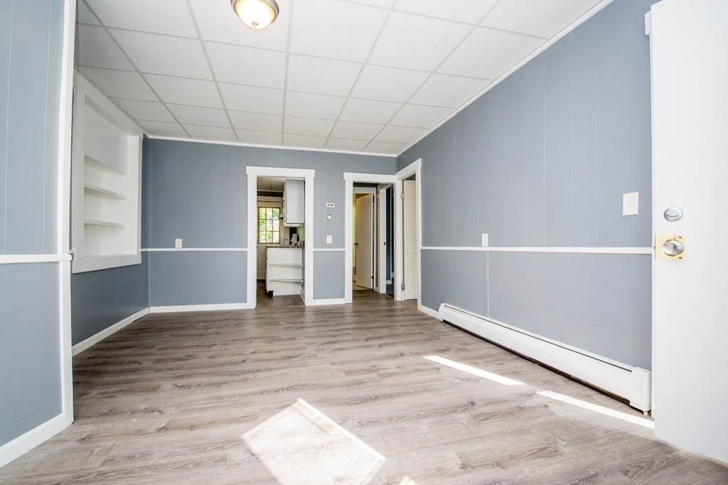 130 Baker Street Fall River, MA 02721 - Photo 9 of 21 a view of an empty room with wooden floor and kitchen