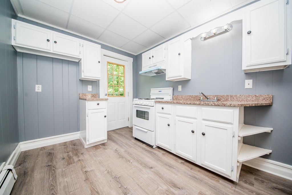 130 Baker Street Fall River, MA 02721 - Photo 10 of 21 a kitchen with granite countertop white cabinets and white appliances
