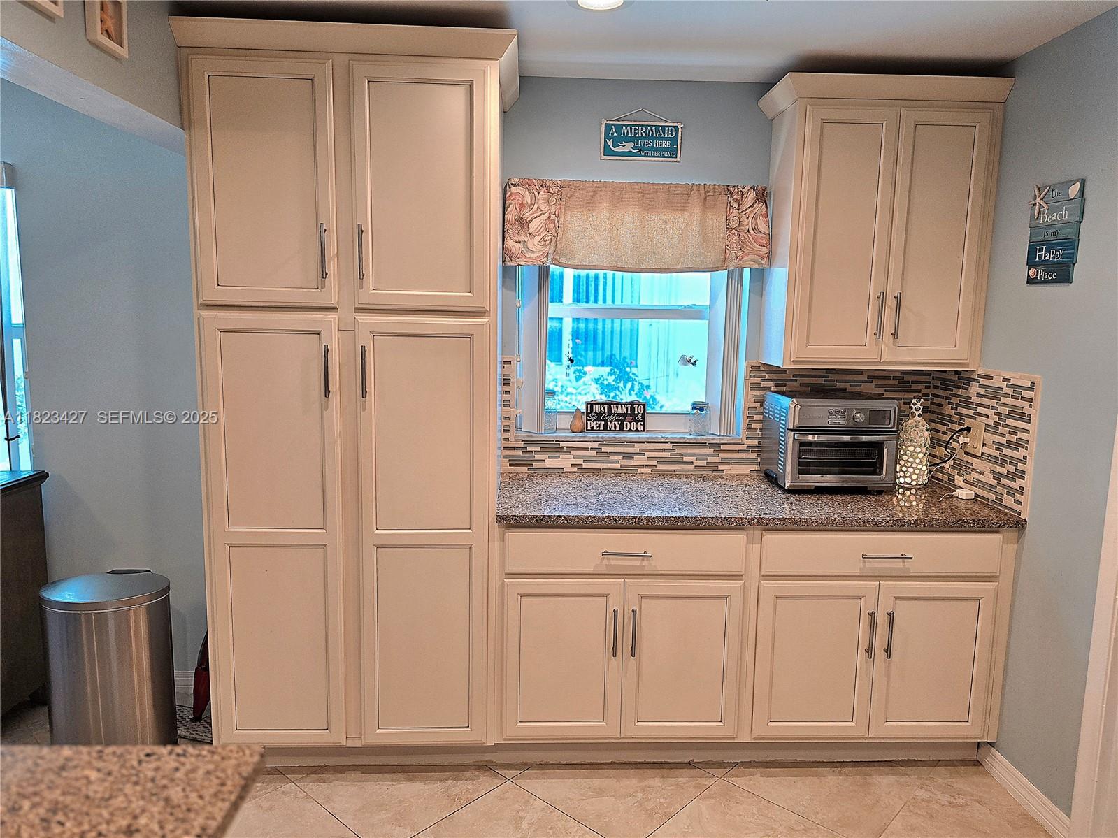1711 Southwest 22nd Street Boynton Beach, FL 33426 - Photo 53 of 60 a kitchen with stainless steel appliances granite countertop white cabinets and a granite counter tops