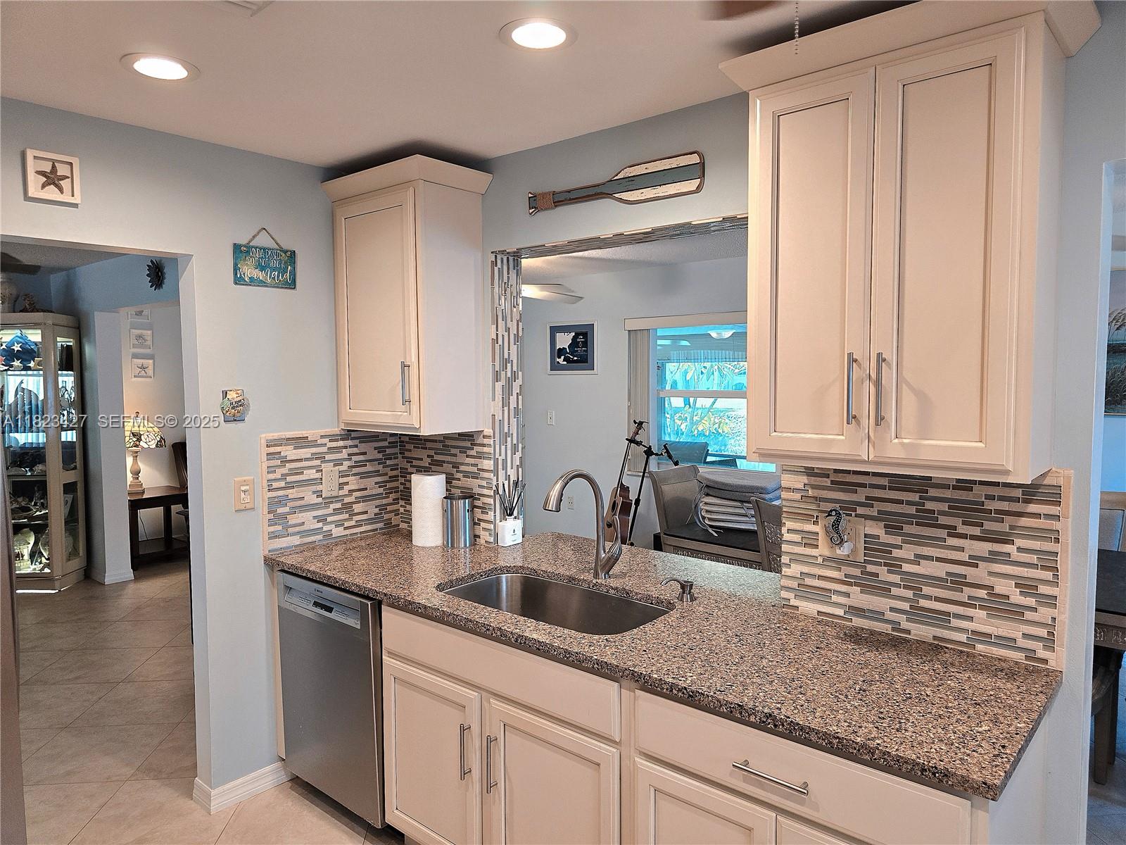 1711 Southwest 22nd Street Boynton Beach, FL 33426 - Photo 55 of 60 a kitchen with stainless steel appliances granite countertop a sink and cabinets