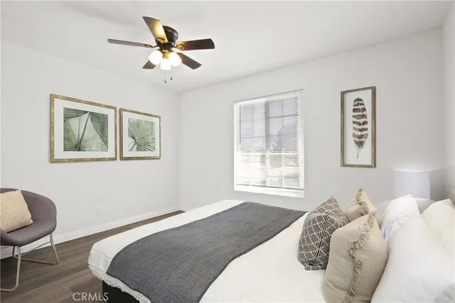 a bedroom with a bed and a chair with a bookshelf