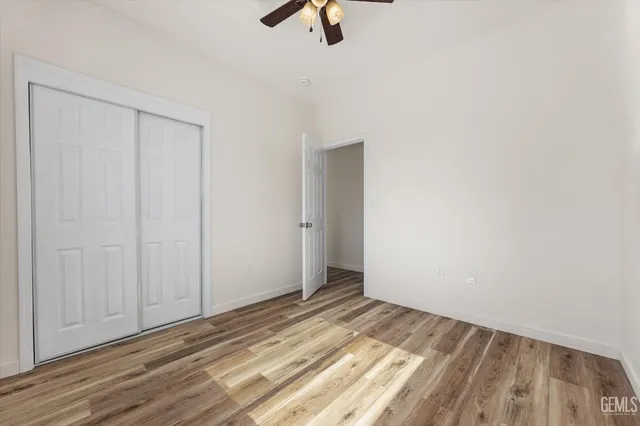 a view of a room with wooden floor and a ceiling fan