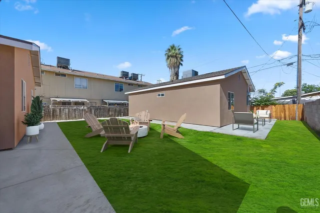 a view of a patio with table and chairs potted plants with floor to ceiling window