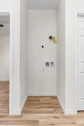 a kitchen with cabinets appliances wooden floor and a window