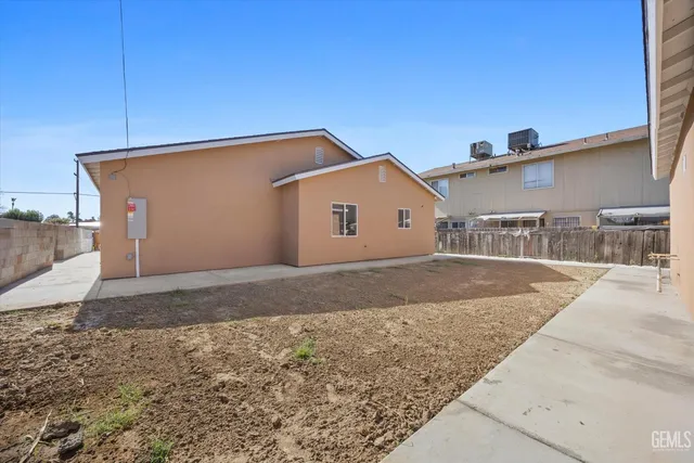 an empty room with a window and a ceiling fan