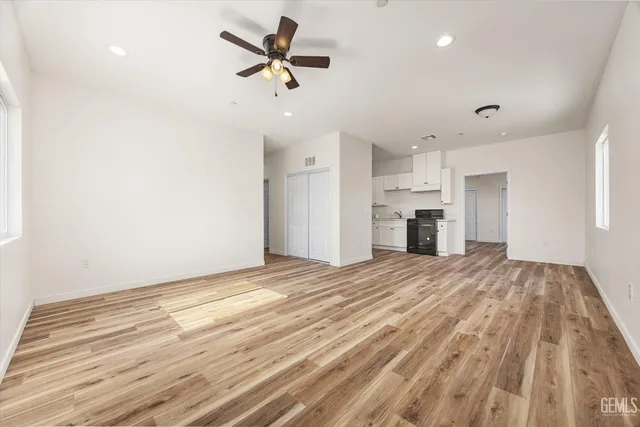 a view of empty room with wooden floor and ceiling fan