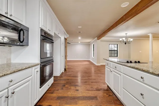 a large kitchen with stainless steel appliances granite countertop a stove and a sink