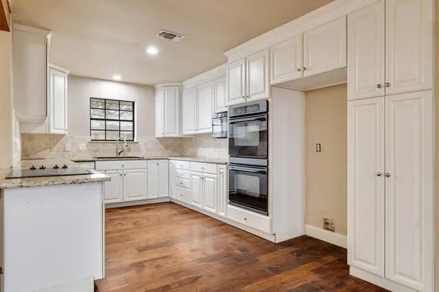a kitchen with granite countertop a refrigerator and a sink