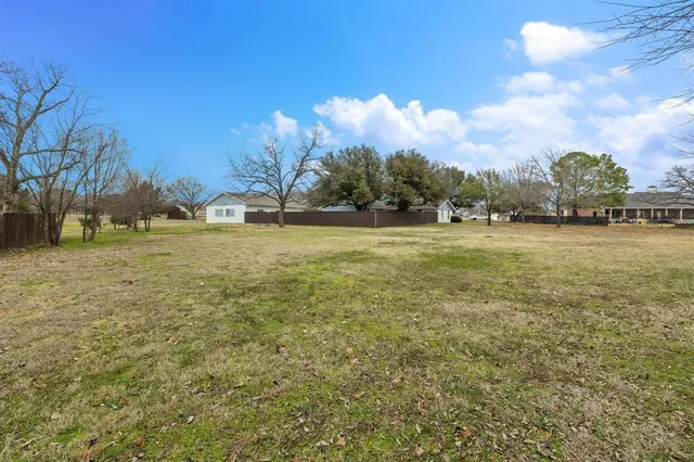 a view of a field with an trees in front of it