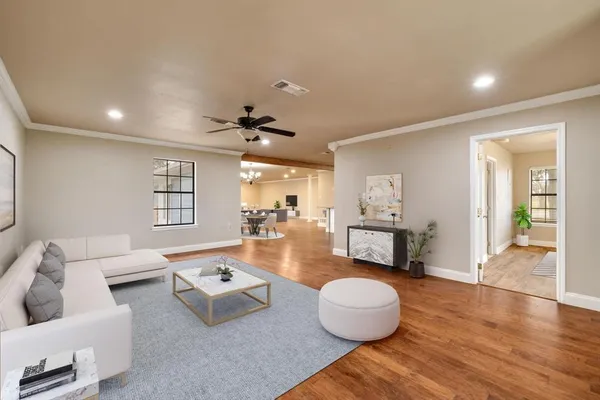 a living room with furniture and a wooden floor