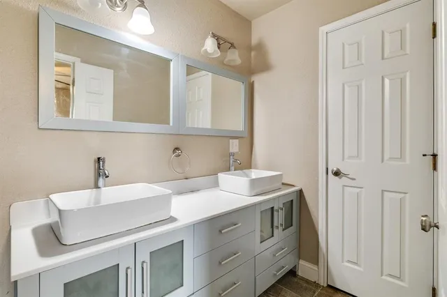 a bathroom with double sink and a mirror