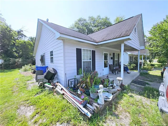 a view of a house with backyard and sitting area