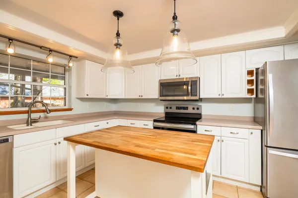 a kitchen with granite countertop a refrigerator stove and microwave