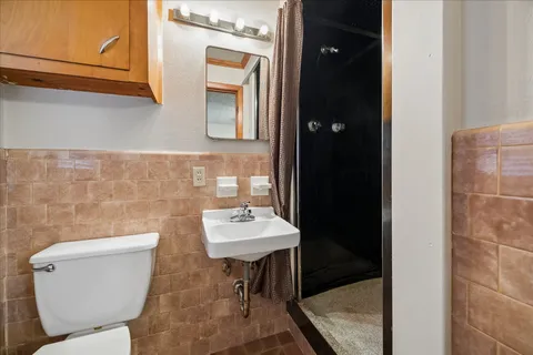 a bathroom with a toilet a sink and mirror