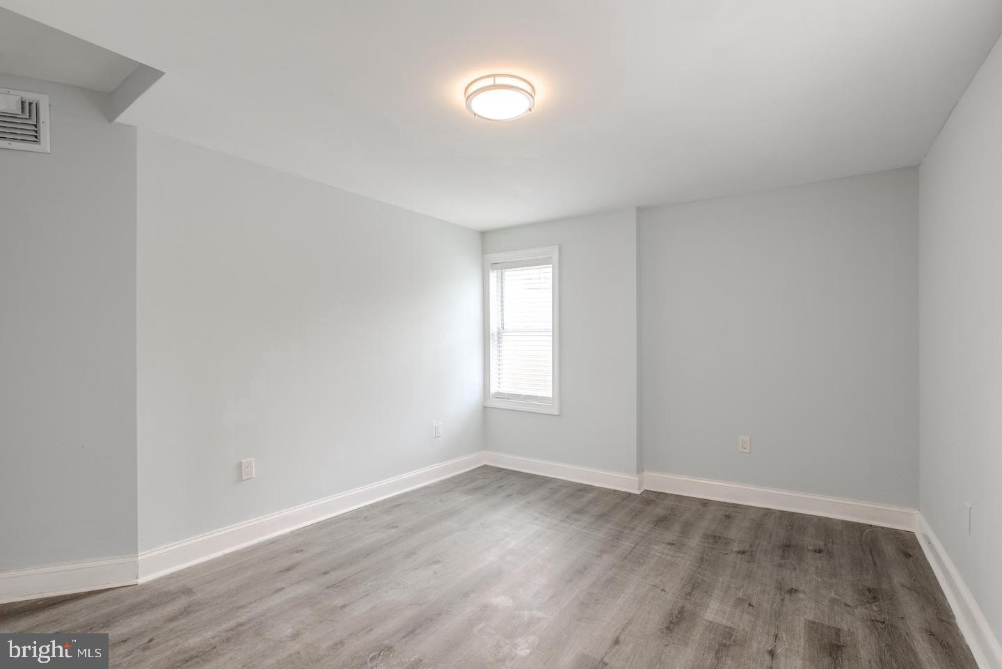 608 9th Street, Unit 2 Chester, PA 19013 - Photo 13 of 13 an empty room with wooden floor and windows