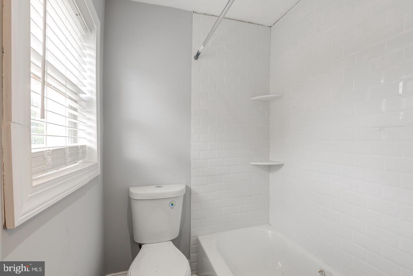 608 9th Street, Unit 2 Chester, PA 19013 - Photo 5 of 13 a white toilet sitting next to a bath tub
