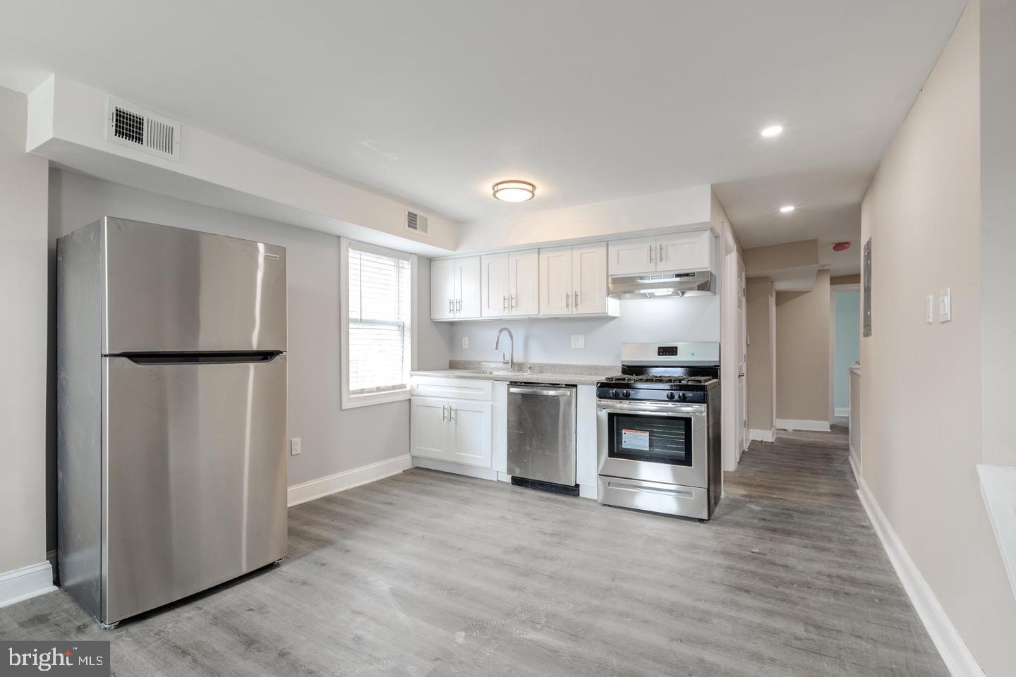 608 9th Street, Unit 2 Chester, PA 19013 - Photo 7 of 13 a kitchen with stainless steel appliances granite countertop a refrigerator and a stove top oven