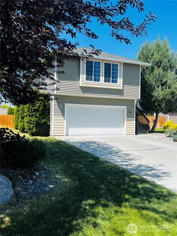 a front view of a house with a yard and a garage