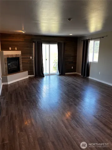 an empty room with wooden floor and fireplace