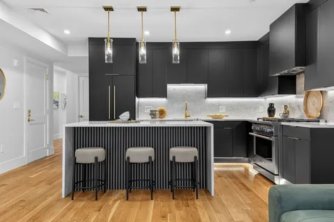 a kitchen with stainless steel appliances granite countertop a sink a stove a dining table and chairs