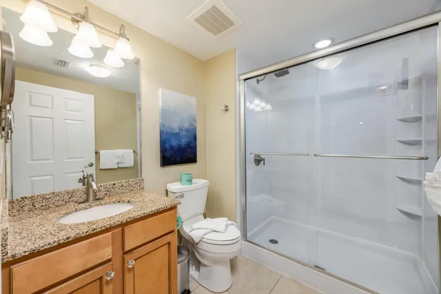 a bathroom with a sink a toilet and shower