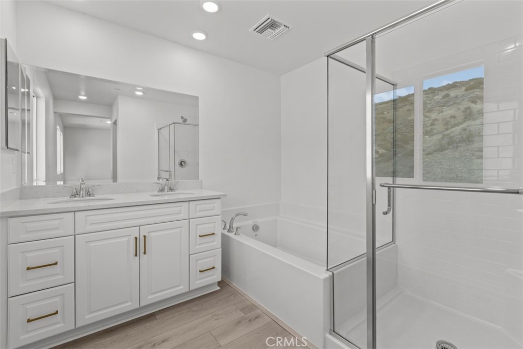 1249 Butterfly Way Banning, CA 92220 - Photo 16 of 18 a spacious bathroom with a shower sink and mirror