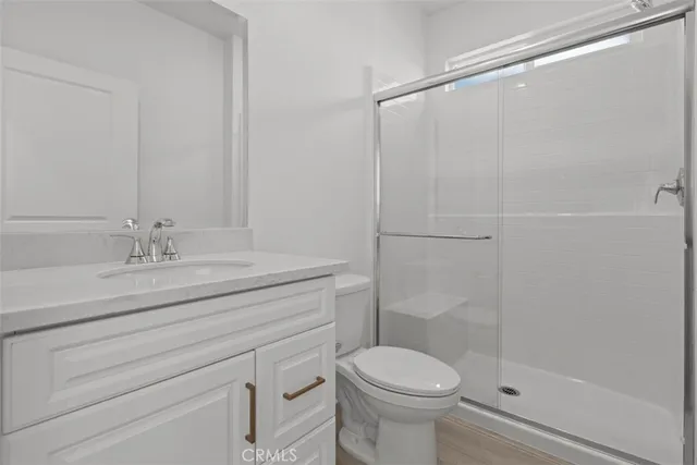 a bathroom with a shower sink vanity mirror and toilet