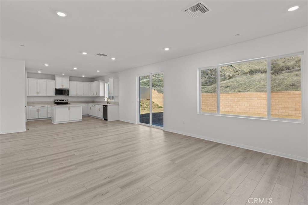 1249 Butterfly Way Banning, CA 92220 - Photo 7 of 18 a view of an empty room with wooden floor and a window
