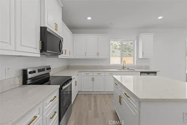 a kitchen with stainless steel appliances granite countertop a stove a sink and a microwave