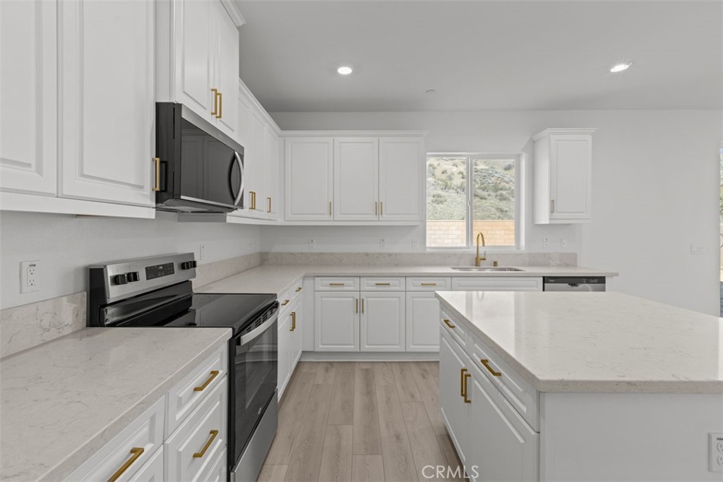 1249 Butterfly Way Banning, CA 92220 - Photo 9 of 18 a kitchen with stainless steel appliances granite countertop a stove a sink and a microwave