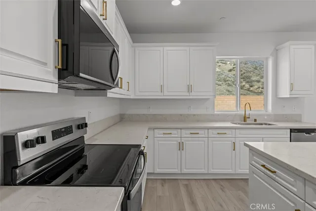 a kitchen with a stove a sink and a microwave