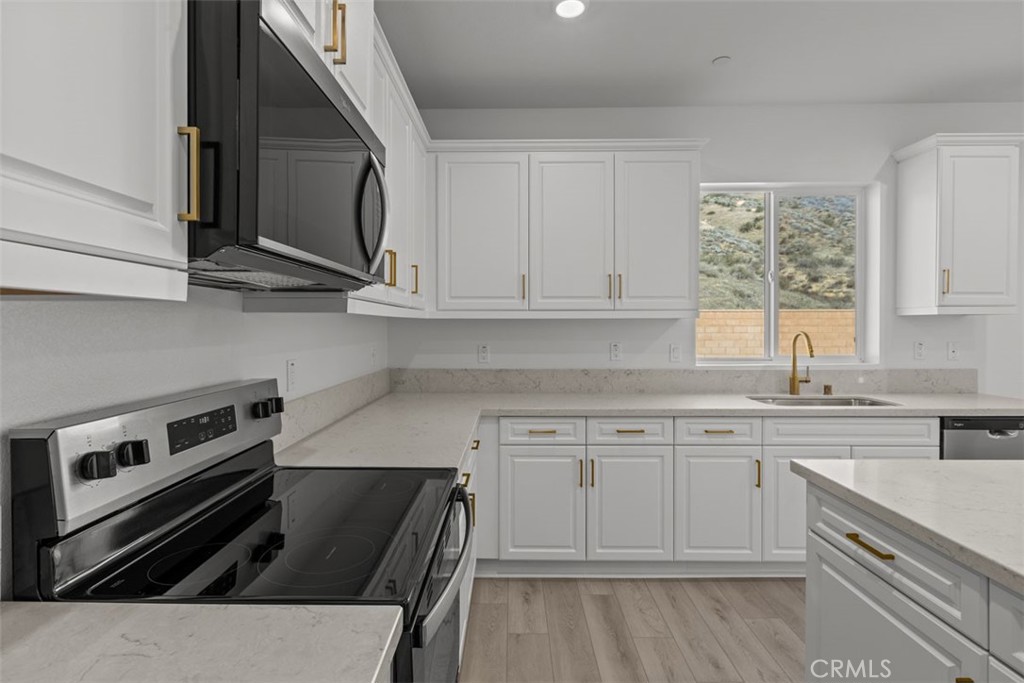1249 Butterfly Way Banning, CA 92220 - Photo 10 of 18 a kitchen with a stove a sink and a microwave